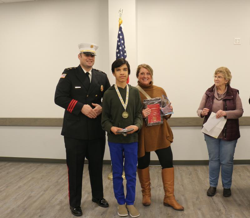 Mariner Middle seventh-grader Christopher Dunson won first place in the Milton Fire Department’s fire prevention contest and went on to win first in the county and state-level competitions as well. Gathered at the Jan. 10 award ceremony are (l-r) MFD President Brian Reynolds Jr., Christopher Dunson, teacher Kristen Low and MFD Ladies Auxiliary President Mary Ann Warrington. ELLEN DRISCOLL PHOTOS